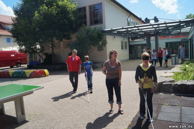 Schüler mit verbundenen Augen und Blindenstöcken auf dem Schulhof